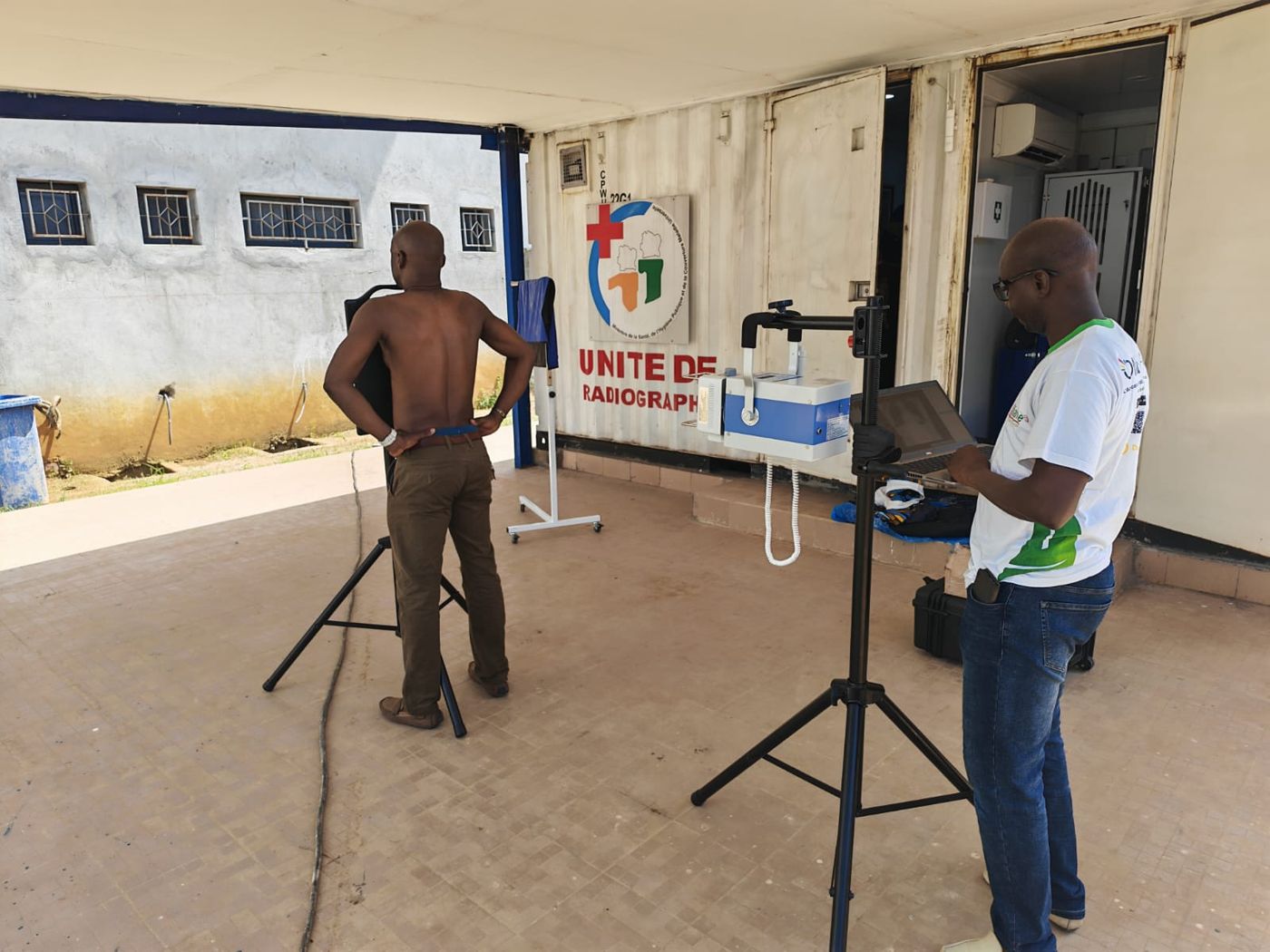 A radiographer positioning a patient for a digital chest X-ray in a screening unit in C&ocirc;te d&rsquo;Ivoire
