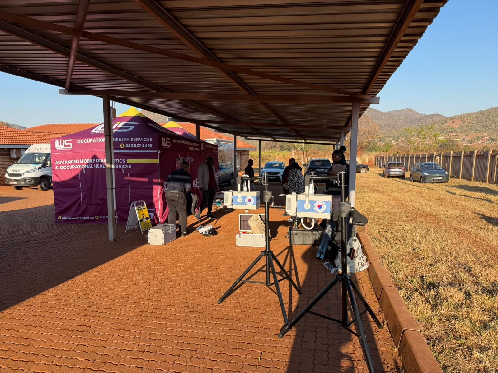 Ultra-portable X-ray equipment set up under a shelter at the Mafefe screening site with the Limpopo mountains behind